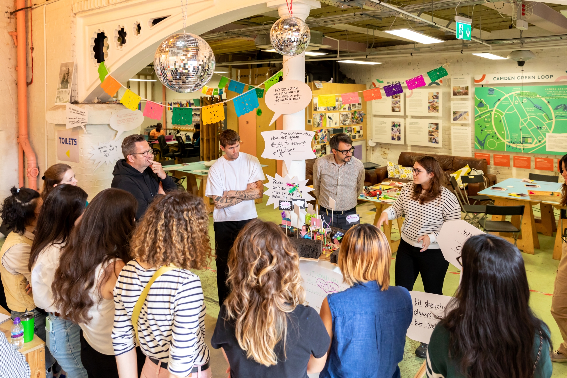 People looking at someone speaking in a colourful space
