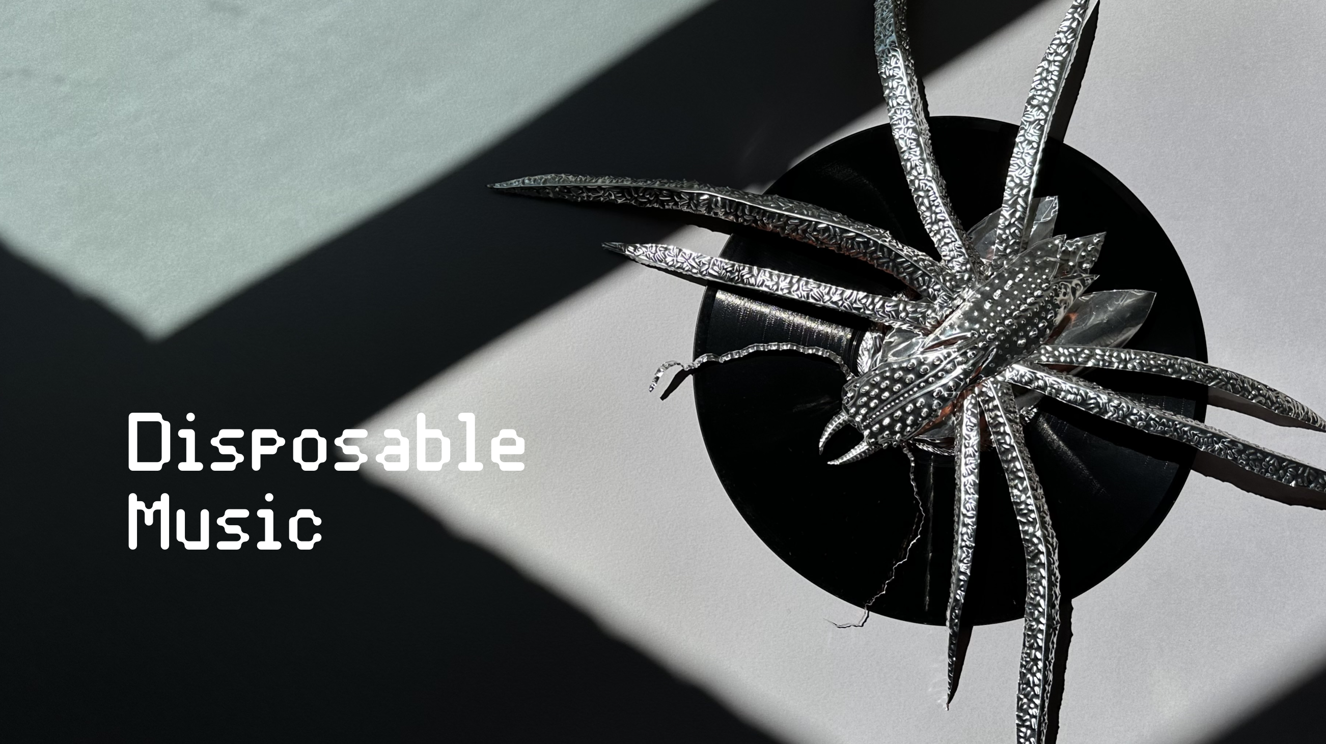 Metal sculpture of a parasite sitting on a vinyl record.